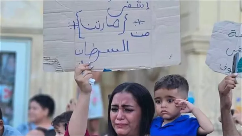 صورة مؤثرة لأم تحتضن طفلها في احتفالات صوم السيدة العذراء.. «يا عذرا اشفي مارتن من السرطان»